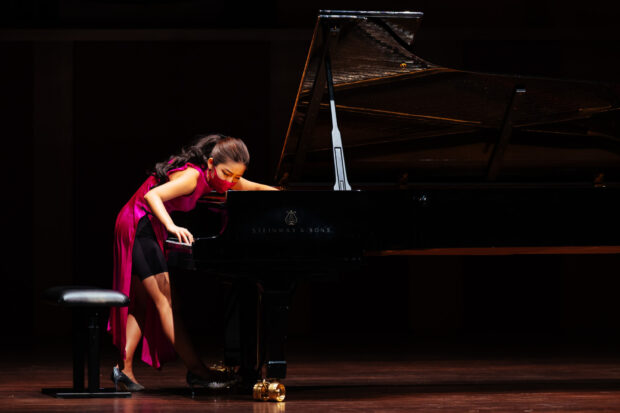 In Churen Li’s recital of Crumb’s “Five Pieces for Piano”, her technique involved plucking and strumming the piano strings with her fingers, and placing a metal paperclip on the vibrating strings to produce a metallic sound. [Photo credit: Nathaniel Lim]