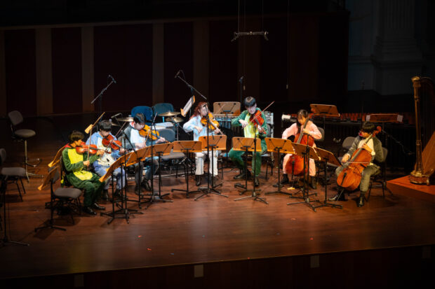SNYO String septet performing in various onesies.